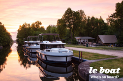 boat docked along canal in fading light, Le Boat logo in right corner