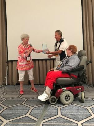 Woman Presenting an Award to a Couple